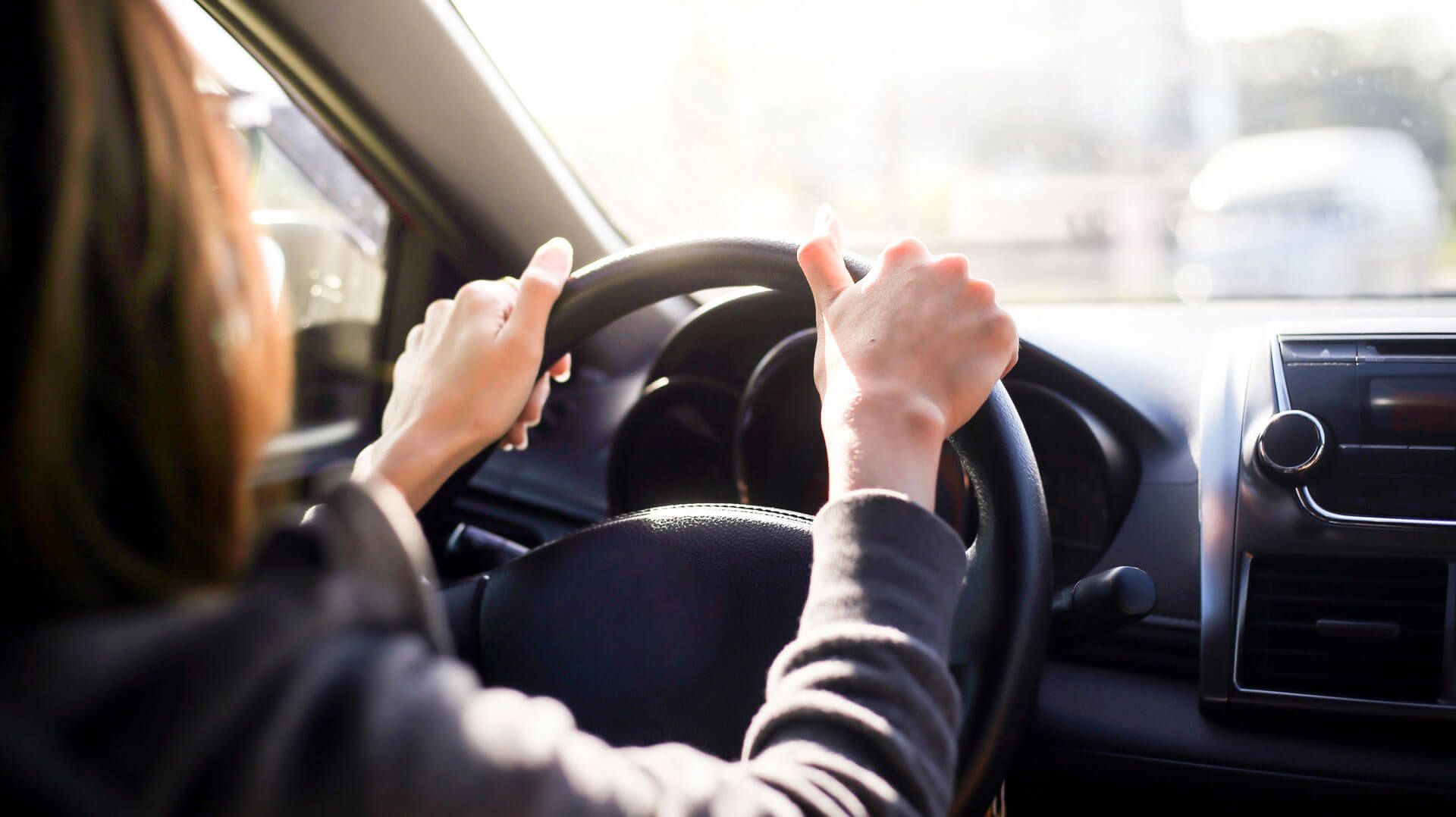 Eine Frau fährt Auto, Nahaufnahme des Lenkrads